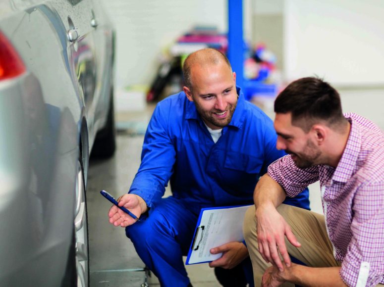 Mechaniker und Kunden besprechen Herstellergarantie beibehalten bei TOP Markenspezialist Autohaus Degener. Spezialist für Peugeot , Citroën